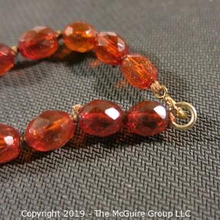 Jewelry: Necklace of 51 graduated and faceted Amber beads, 9 x 7 – 22 x 18mm, knotted – moderate wear.