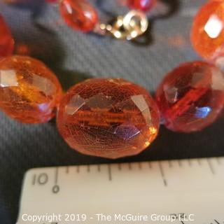 Jewelry: Necklace of 51 graduated and faceted Amber beads, 9 x 7 – 22 x 18mm, knotted – moderate wear.