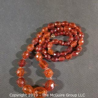 Jewelry: Necklace of 51 graduated and faceted Amber beads, 9 x 7 – 22 x 18mm, knotted – moderate wear.