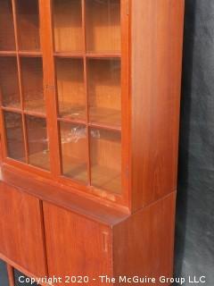 Danish Mid Century Stepped Back glass front cabinet; two doors over two sliding doors; base is 36W x 28T x 17D; top is 36W x 36T x 13D