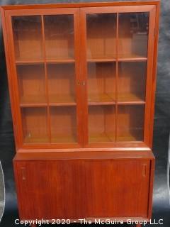 Danish Mid Century Stepped Back glass front cabinet; two doors over two sliding doors; base is 36W x 28T x 17D; top is 36W x 36T x 13D