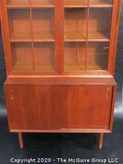 Danish Mid Century Stepped Back glass front cabinet; two doors over two sliding doors; base is 36W x 28T x 17D; top is 36W x 36T x 13D