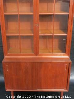 Danish Mid Century Stepped Back glass front cabinet; two doors over two sliding doors; base is 36W x 28T x 17D; top is 36W x 36T x 13D