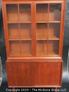 Danish Mid Century Stepped Back glass front cabinet; two doors over two sliding doors; base is 36W x 28T x 17D; top is 36W x 36T x 13D