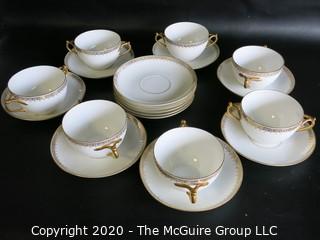 Set of 7 Limoges Porcelain Double Handle Cups and Saucers with 5 additional saucers made by D & C Delinieres & Co. White with Gilt Design. Made in France 