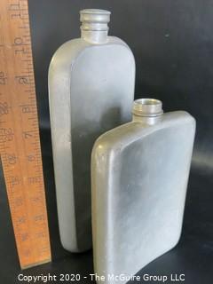 Two Metal Flasks.  Measures approximately 11" and 9" tall.  As is, one missing top.