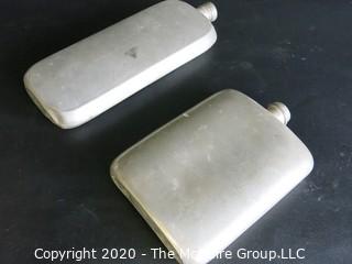 Two Metal Flasks.  Measures approximately 11" and 9" tall.  As is, one missing top.