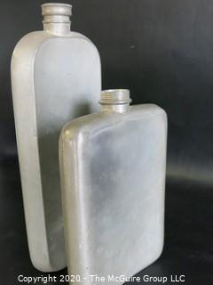 Two Metal Flasks.  Measures approximately 11" and 9" tall.  As is, one missing top.