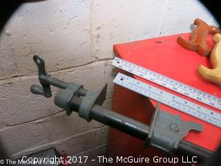 Collection of tools including bar clamps, metal rulers, square, hand saws, hand drill, hack saw, scroll saw