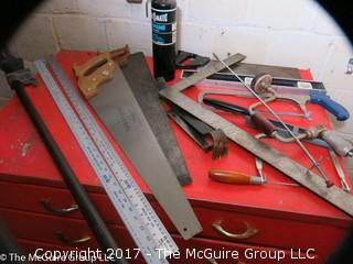 Collection of tools including bar clamps, metal rulers, square, hand saws, hand drill, hack saw, scroll saw