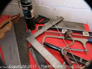 Collection of tools including bar clamps, metal rulers, square, hand saws, hand drill, hack saw, scroll saw