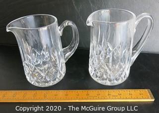 Set of Two Crystal Pitchers. Measure approximately 6 1/2" tall.  Some damage on one of the handles.
