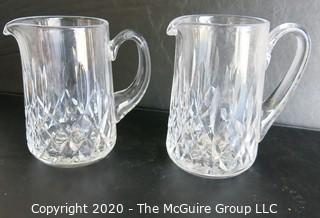 Set of Two Crystal Pitchers. Measure approximately 6 1/2" tall.  Some damage on one of the handles.
