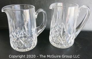 Set of Two Crystal Pitchers. Measure approximately 6 1/2" tall.  Some damage on one of the handles.
