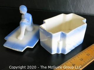 Blue and White Art Deco Pottery Talcom Powder Box with Figure on Lid.  Some chips on edges. .  Measures approximately 5 1/2" x 5".
