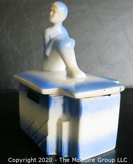 Blue and White Art Deco Pottery Talcom Powder Box with Figure on Lid.  Some chips on edges. .  Measures approximately 5 1/2" x 5".
