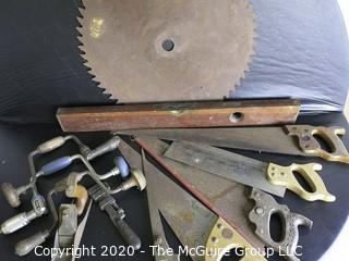 Large Collection of Tools and Farm Equipment.  Includes Hand Saws, Hand Brace Drills, Wrench, Level and Very Large Tractor Blade.  Blade measures approximately 20" in diameter. 