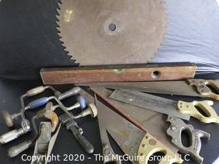 Large Collection of Tools and Farm Equipment.  Includes Hand Saws, Hand Brace Drills, Wrench, Level and Very Large Tractor Blade.  Blade measures approximately 20" in diameter. 