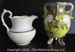 Large Ceramice Pitcher with Gilt Decoration and Yellow Urn Style Vase with White Floral Decoration.  Measures approximately 14". 