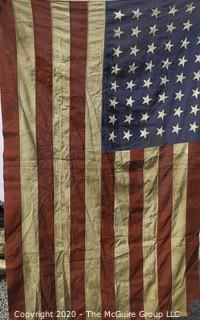 Antique 48 Star American Flag with Stitched Stripes and Stars.  Damage in the bottom corner that has been repaired. Measures approximately 45 x 67".