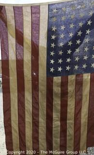 Antique 48 Star American Flag with Stitched Stripes and Stars.  Damage in the bottom corner that has been repaired. Measures approximately 45 x 67".