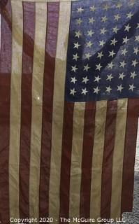 Antique 48 Star American Flag with Stitched Stripes and Stars.  Damage in the bottom corner that has been repaired. Measures approximately 45 x 67".