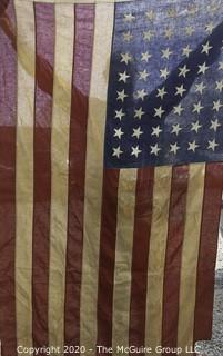 Antique 48 Star American Flag with Stitched Stripes and Stars.  Damage in the bottom corner that has been repaired. Measures approximately 45 x 67".