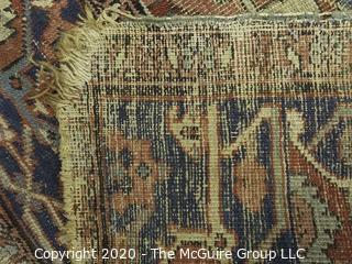 Hand Knotted Wool Rug with Blue Ground.  Poor condition with some holes and much wear.  Measures approximately 133" x 115"