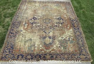 Hand Knotted Wool Rug with Blue Ground.  Poor condition with some holes and much wear.  Measures approximately 133" x 115"