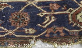 Hand Knotted Wool Rug with Blue Ground.  Poor condition with some holes and much wear.  Measures approximately 133" x 115"