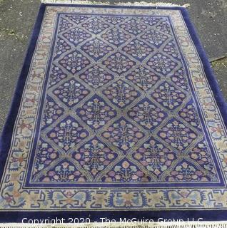 Chinese, Circa 1935, Hand Knotted Wool on Wool Featuring Rectangular Field with Diamond Shaped Car touches Filled with Multi Colored Florettes on Dark Blue Ground.  Measures approximately 108" x 72". Some staining and discoloration. 