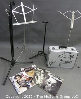 Collection including musical accessories box, guitar stands, sheet music stands, and several Rolling Stones Magazines