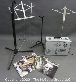 Collection including musical accessories box, guitar stands, sheet music stands, and several Rolling Stones Magazines