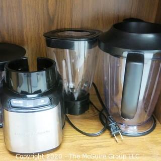 Wood Book Shelf Full of Cleaning & Entertaining Items Including Several Blenders, and Cookware.  Room 20 Kitchen