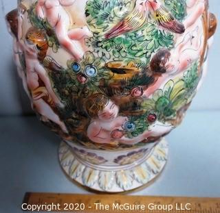 Vintage Porcelain Hand Painted Italian Capodimonte Urn with Lid and Handles with Frolicking Figurals & Cherubs.  Measures approximately 17" tall with lid. 
