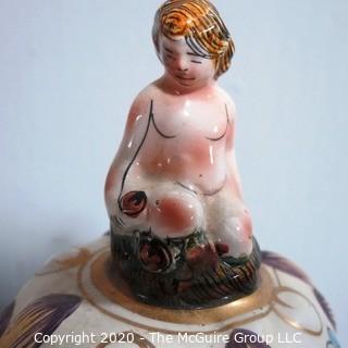 Vintage Porcelain Hand Painted Italian Capodimonte Urn with Lid and Handles with Frolicking Figurals & Cherubs.  Measures approximately 17" tall with lid. 
