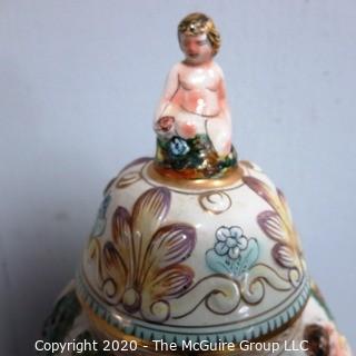 Vintage Porcelain Hand Painted Italian Capodimonte Urn with Lid and Handles with Frolicking Figurals & Cherubs. Several Repairs and chips. Measures approximately 17" tall with lid. 
