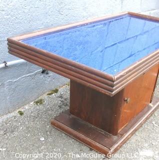 Vintage Art Deco Coffee Table with Bar Cabinet Base and Blue Glass Mirror Top.  Measures approximately 33" long and 18 Wide.  Some separation of top from base, but should be easy to repair