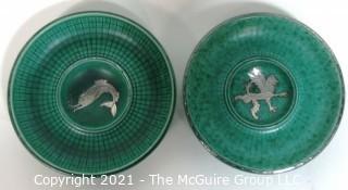 (2) Gustavsberg Argenta Stoneware Pottery Trays or Plates Designed by Wilhelm Kage with Silver Lion and Fish on Jade Green Base. Measures approximately 7" in diameter.