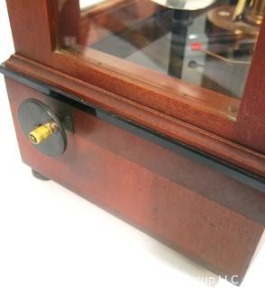 Antique Triple Beam Balance Gold or Apothecary Cabinet Scale in a Glass and Wood Case by Christian Becker, New York.. It has glass panels on all four side and has one drawer with weights and other accessories.   It measures approximately 18" x 16" x 9".