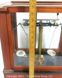 Antique Triple Beam Balance Gold or Apothecary Cabinet Scale in a Glass and Wood Case by Christian Becker, New York.. It has glass panels on all four side and has one drawer with weights and other accessories.   It measures approximately 18" x 16" x 9".