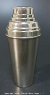 Small Silver Plated Cocktail Shaker with Four Matching Cups. Made in Germany.  Measures approximately 6 1/2" tall and each small cup has different color enamel edge decoration.