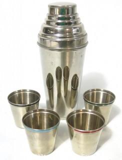 Small Silver Plated Cocktail Shaker with Four Matching Cups. Made in Germany.  Measures approximately 6 1/2" tall and each small cup has different color enamel edge decoration.