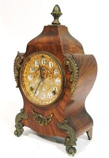 Antique 1904 Ansonia Calais Louis XIV Style 8 Day Mantel Clock in Faux Wood Grained Case.  It measures approximately  7 1/2 inches wide, 14 inches tall & 4 1/2 inches deep.