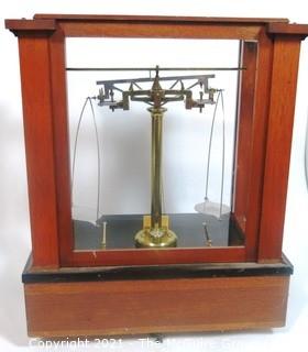 Antique Triple Beam Balance Gold or Apothecary Cabinet Scale in a Glass and Wood Case Made by Voland & Sons of New Rochelle, NY, 1912. It has glass panels on all four side and has one drawer with box of scale weights. It measures approximately 21" x 16" x 9".