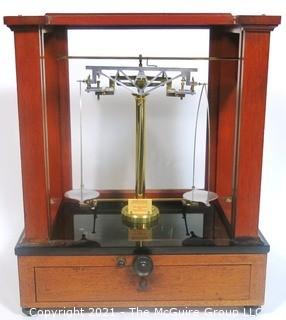 Antique Triple Beam Balance Gold or Apothecary Cabinet Scale in a Glass and Wood Case Made by Voland & Sons of New Rochelle, NY, 1912. It has glass panels on all four side and has one drawer with box of scale weights. It measures approximately 21" x 16" x 9".