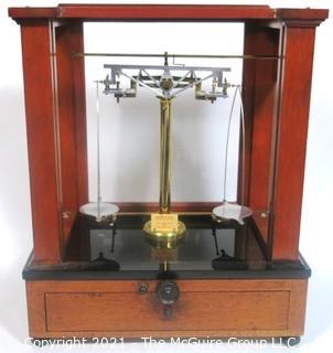 Antique Triple Beam Balance Gold or Apothecary Cabinet Scale in a Glass and Wood Case Made by Voland & Sons of New Rochelle, NY, 1912. It has glass panels on all four side and has one drawer with box of scale weights. It measures approximately 21" x 16" x 9".