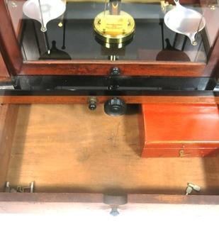 Antique Triple Beam Balance Gold or Apothecary Cabinet Scale in a Glass and Wood Case Made by Voland & Sons of New Rochelle, NY, 1912. It has glass panels on all four side and has one drawer with box of scale weights. It measures approximately 21" x 16" x 9".