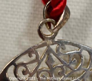 Pierced Sterling Silver Pendant on Red Cord Necklace.  Measures approximately 2" in diameter and 11.2 g weight. 