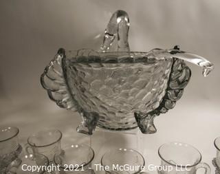 Unmarked Clear Cambridge Glass Swan Punch Bowl with 12 Swan Cups & Ladle. It measures approximately 15 long, 10" tall and 10" wide.  Chip in back tail feather. 